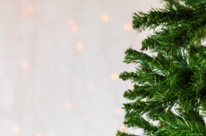 Festive Christmas close up background of bare artificial pine tree.